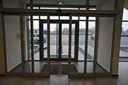 Sistema di porte scorrevoli con telaio in alluminio all'ingresso di un edificio. Dotato di un meccanismo di scorrimento automatico basato su sensori di movimento