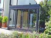 Veranda di vetro costruita da pannelli di vetro montati su un telaio in acciaio con porte scorrevoli