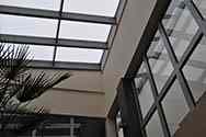 Tetto in vetro coprendo una serra in un edificio per uffici. Pannelli di vetro installati su un telaio in acciaio zincato montato sul tetto.