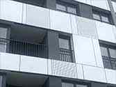 Pannelli in composito alucobond per facciata, dietro di esso ringhiera del balcone in acciaio