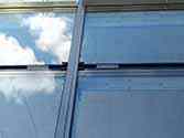 Pannelli in vetro fissati alla struttura di supporto con profili in alluminio. Elastici per l'isolamento